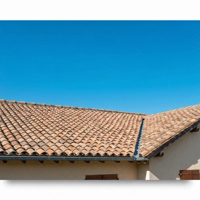 Image montrant une toiture en tuiles de terre cuite typique de la Charente avec un ciel dégagé