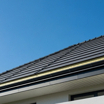Modern house roof with visible insulation layers and a blue sky overhead, no text, no words, no typography, no labels, clean image