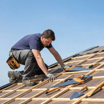 Un couvreur professionnel inspectant un toit de maison à Angoulême, évaluant les dommages potentiels
