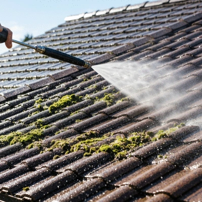 Residential roof being cleaned with a pressure washer