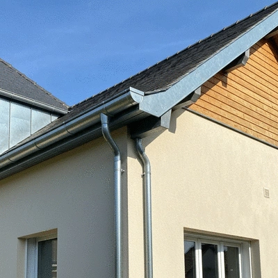Gouttière en zinc moderne sur une maison récemment rénovée
